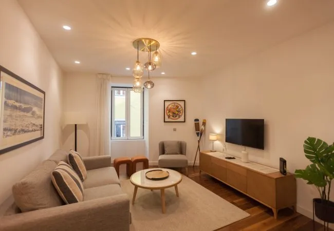 Una sala de estar con asientos alrededor de una mesa de centro y un televisor.