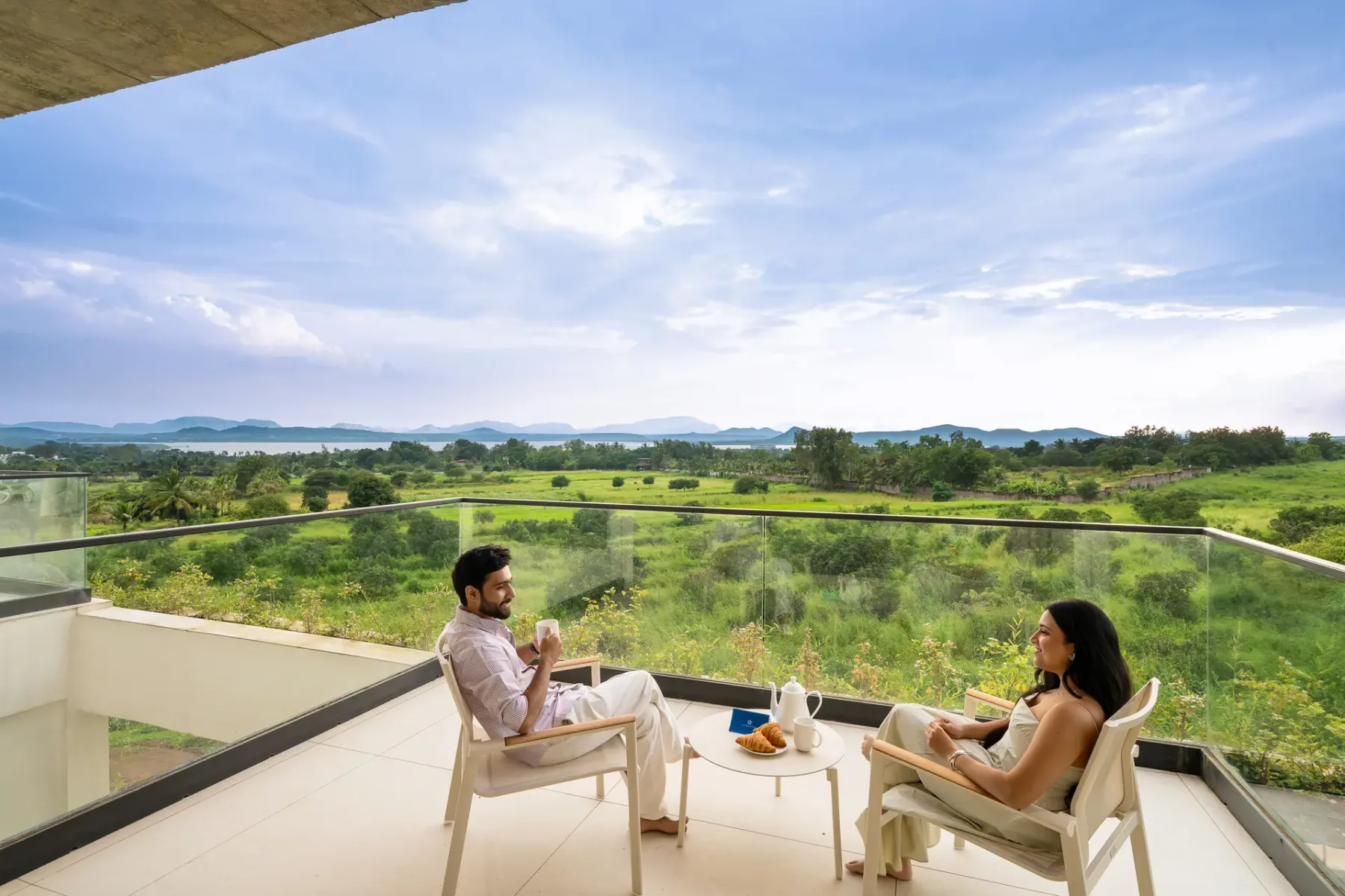 Una terraza con asientos ofrece vistas a campos verdes y colinas lejanas.