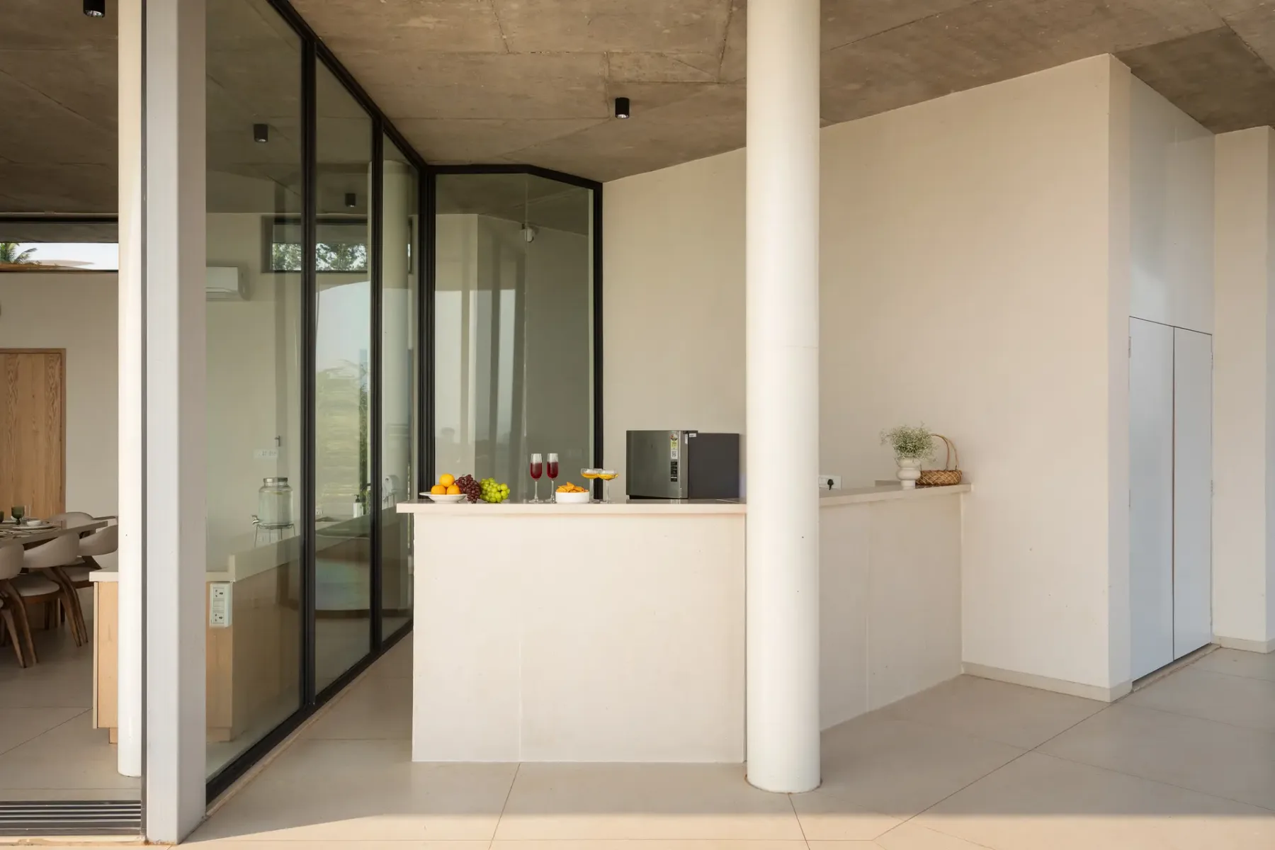 Una cocina moderna con una isla clara y paredes de vidrio.