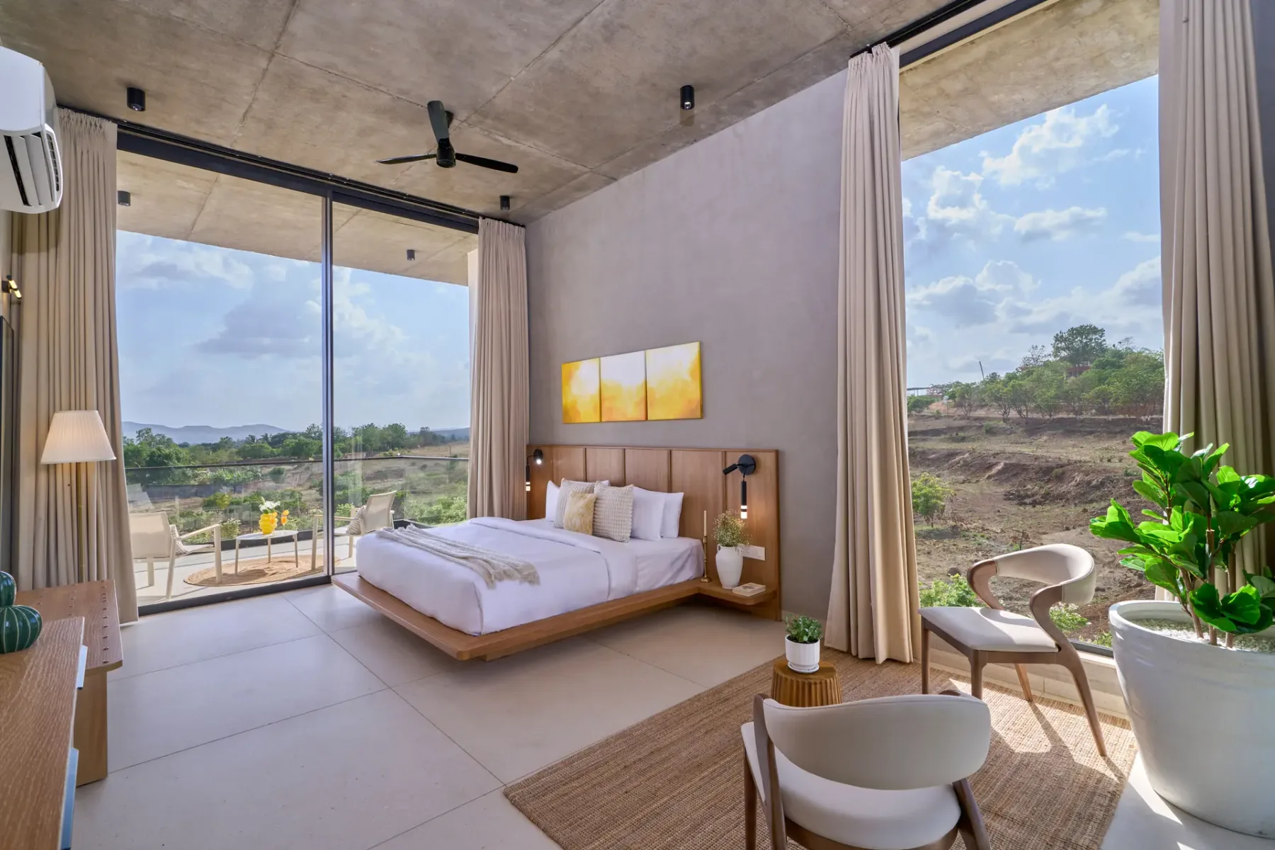 Un dormitorio con una cama y grandes ventanales con vistas a la vegetación.