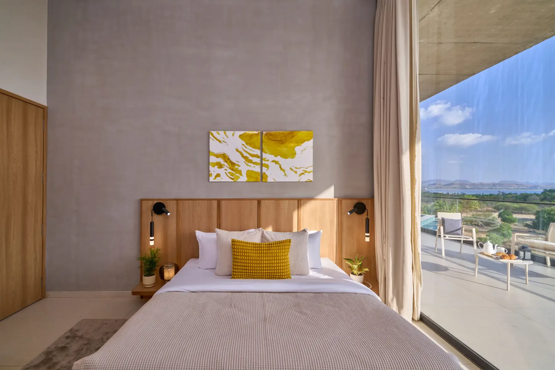 Un dormitorio con una cama tendida y una puerta de vidrio que da a una terraza.