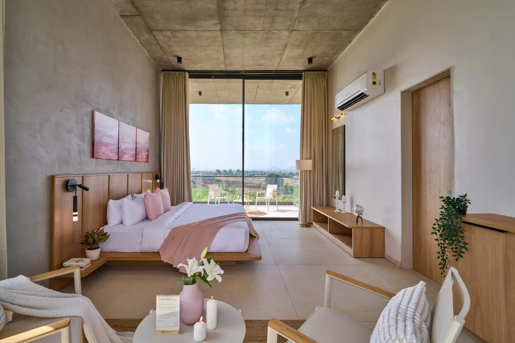 Un dormitorio luminoso con una cama frente a grandes puertas de vidrio y un balcón.