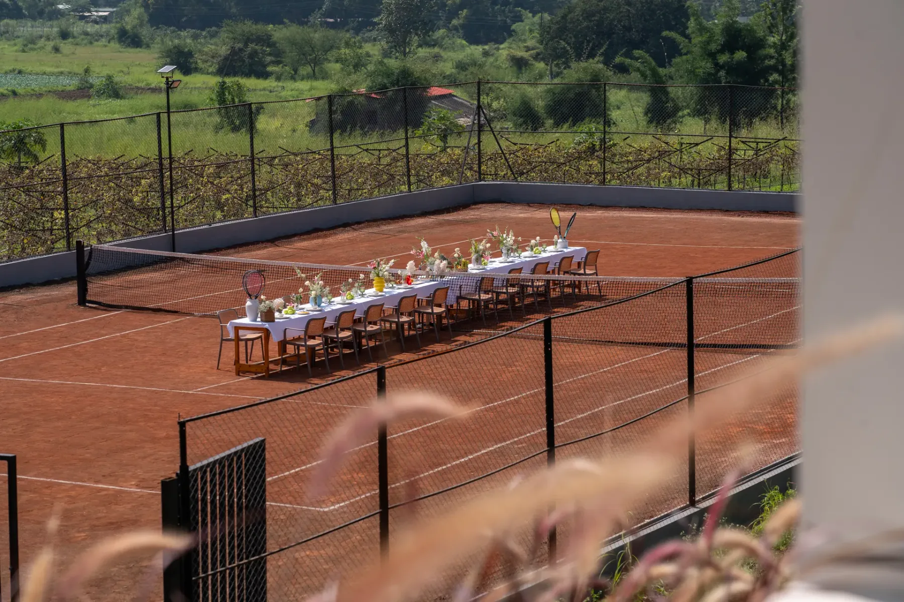 Una pista de tenis está preparada para un evento al aire libre con una mesa larga.