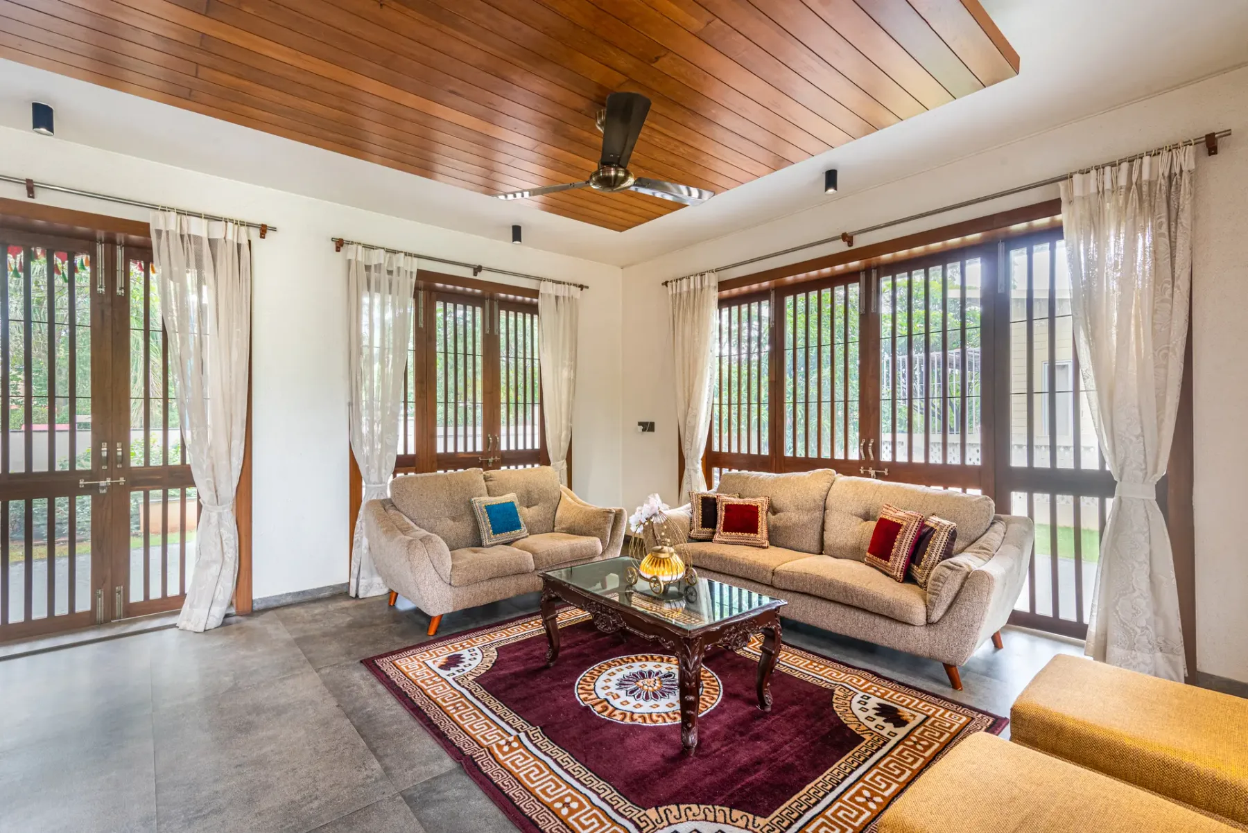 A living room with seating arranged around a glass coffee table and rug.