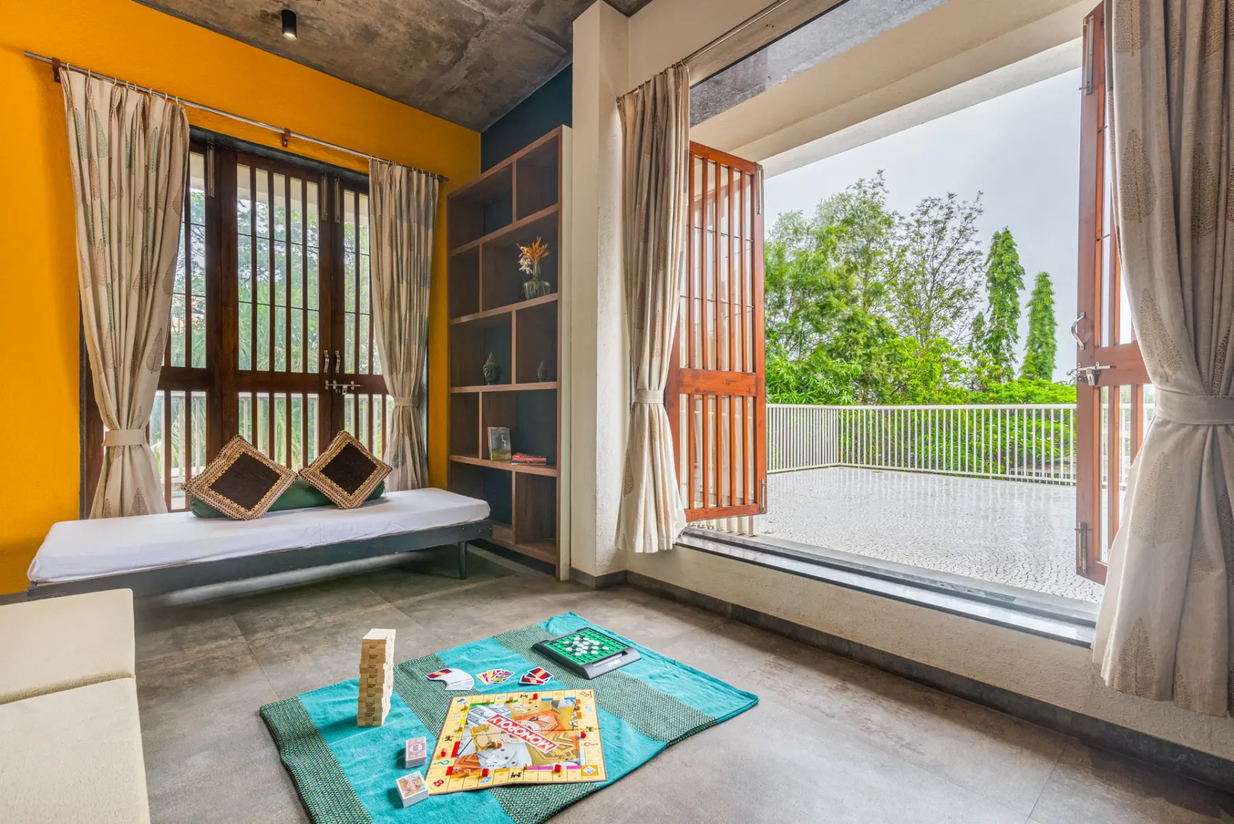 A sitting area with floor cushions and an open doorway to a balcony.
