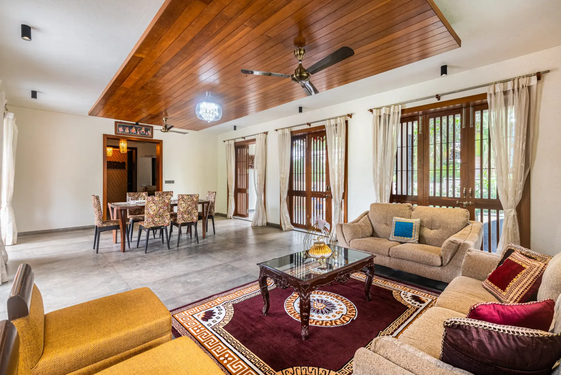 A spacious living room with seating around a patterned rug and coffee table.