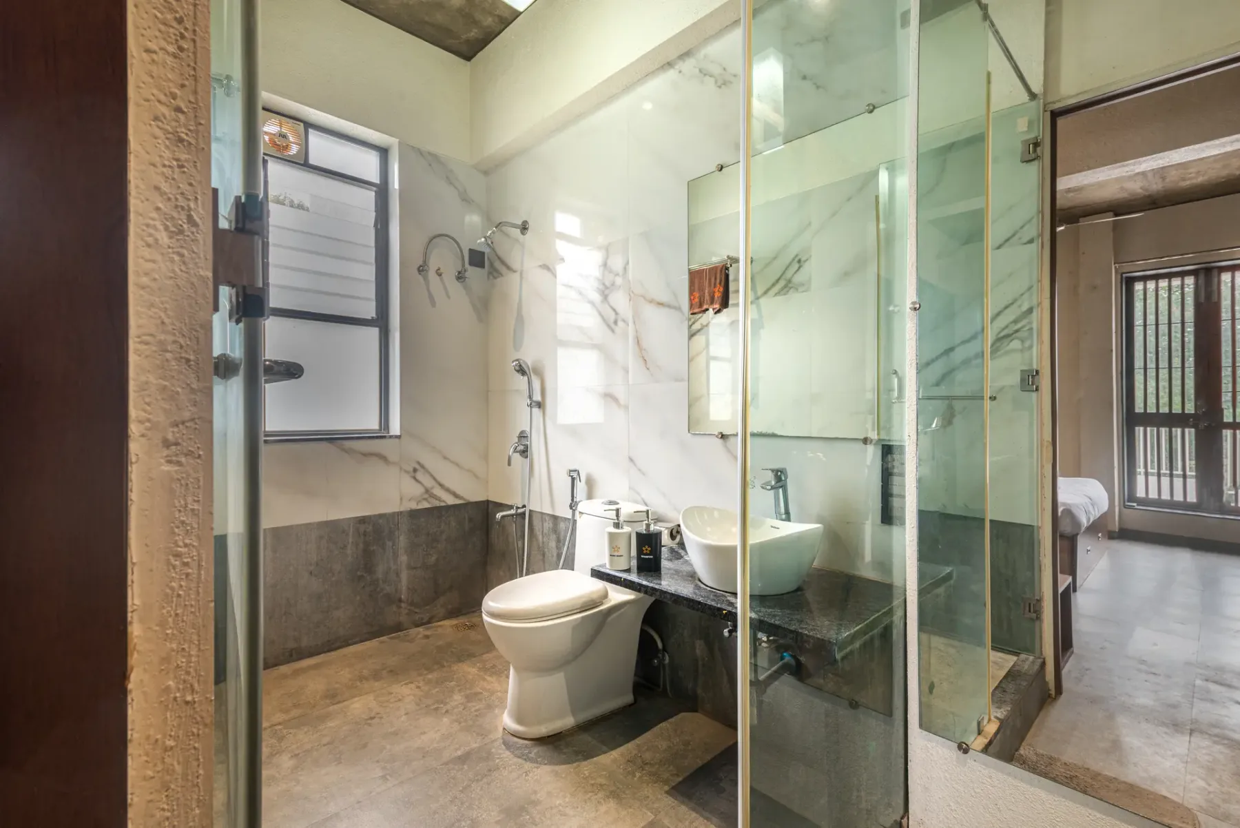 A bathroom with a toilet, sink, and glass shower.