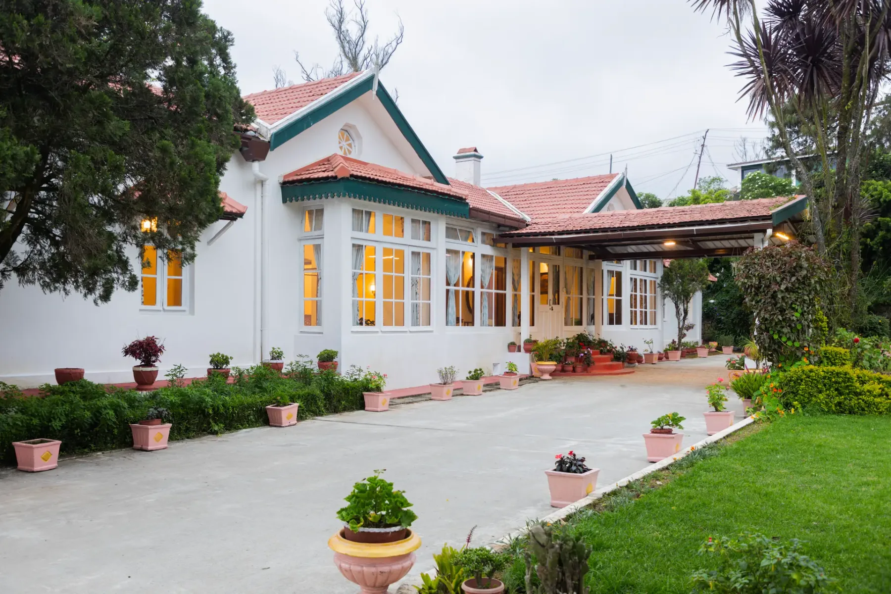 Un edificio blanco con una entrada cubierta da a un patio pavimentado.