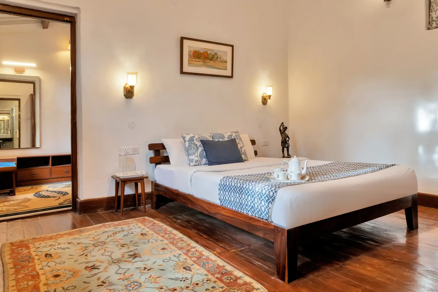 Un dormitorio con una cama grande, ropa de cama estampada y una alfombra en el suelo.