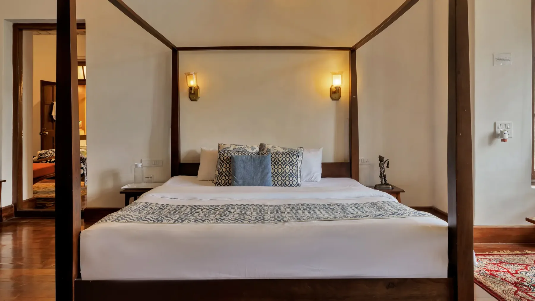 Un dormitorio cuenta con una cama grande, almohadas estampadas y luces de pared a juego.