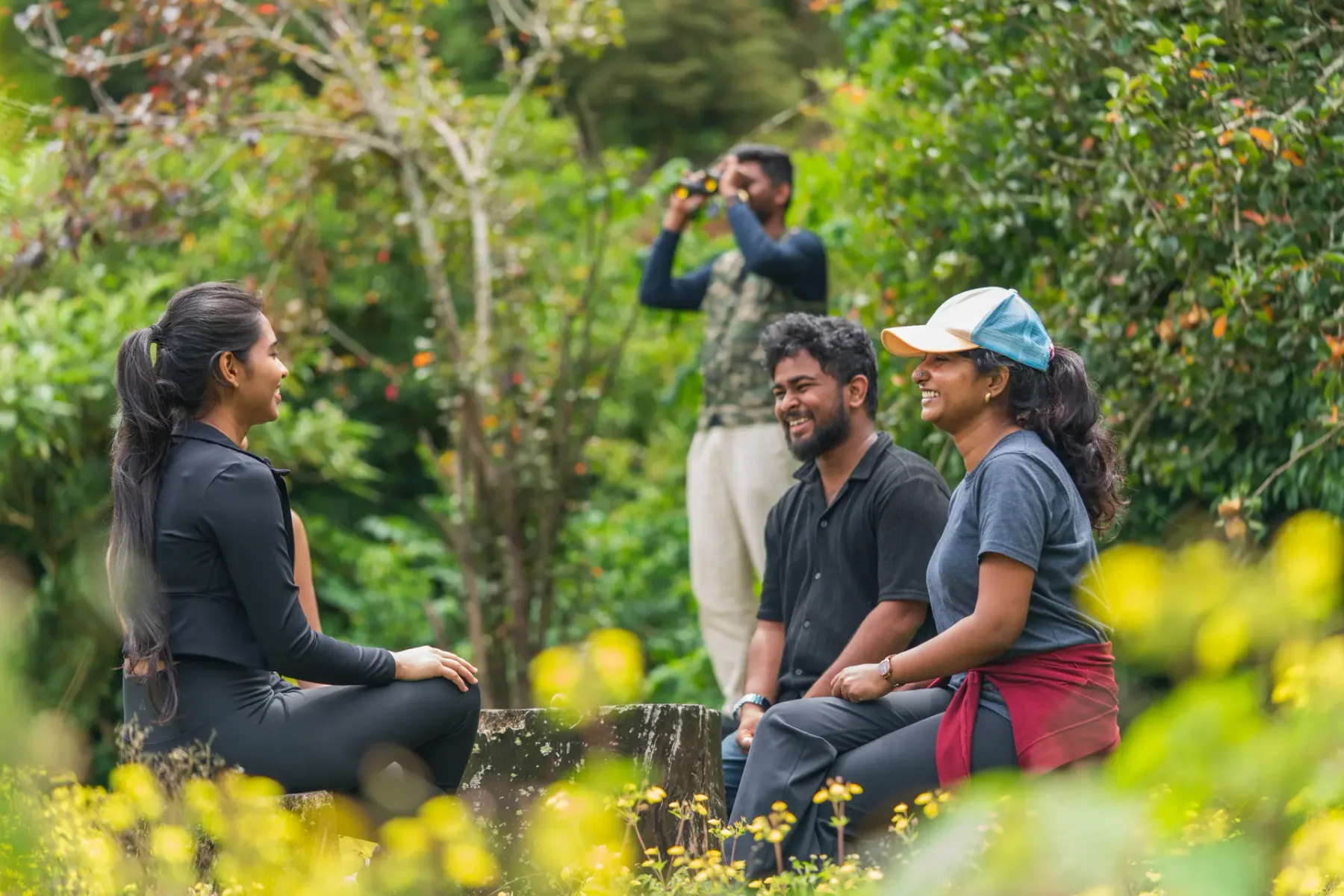 Varias personas se reúnen al aire libre en un jardín, mientras alguien toma una fotografía.