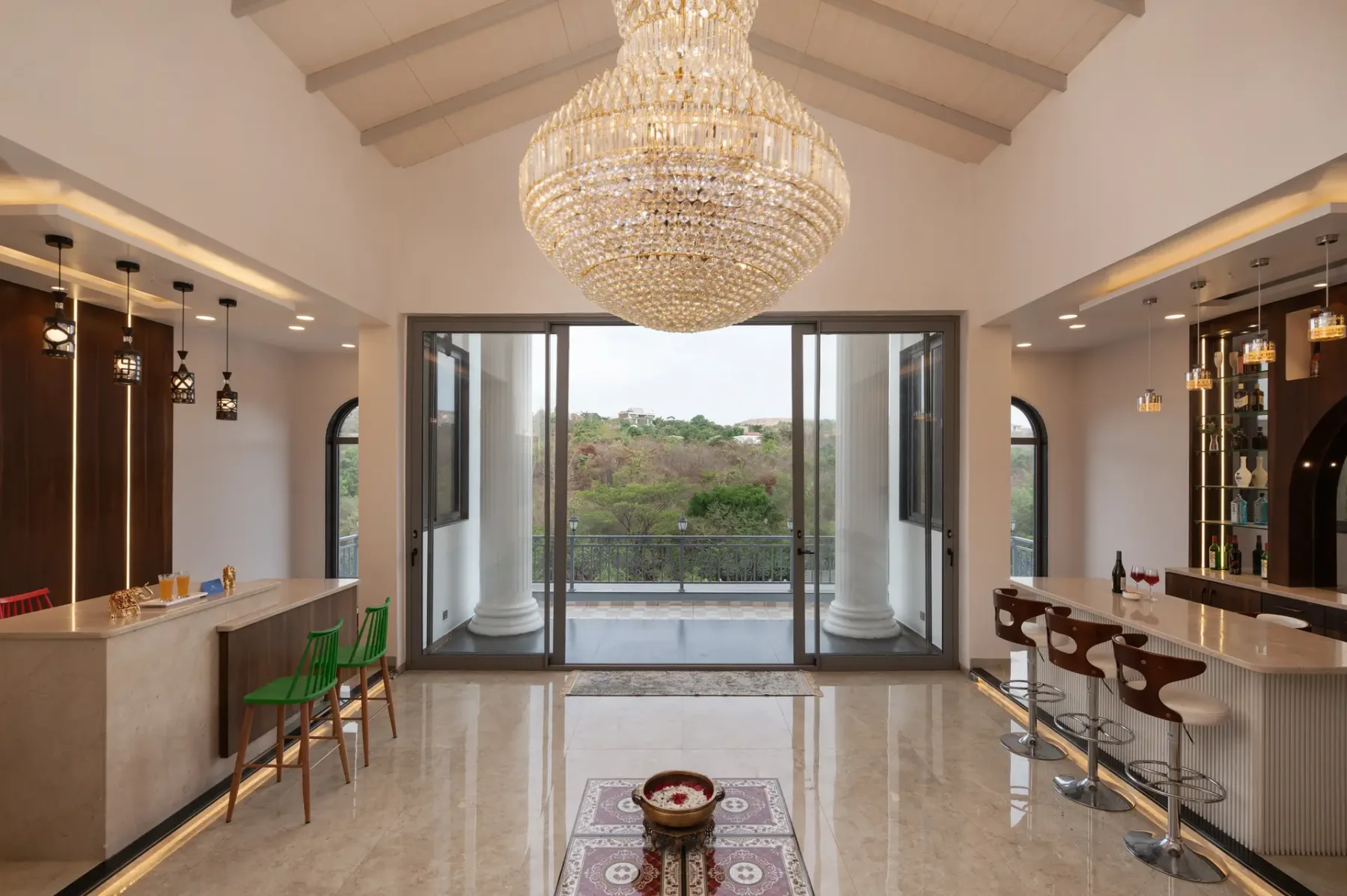 An elegant indoor lounge with counter seating and large glass doors opening onto greenery.