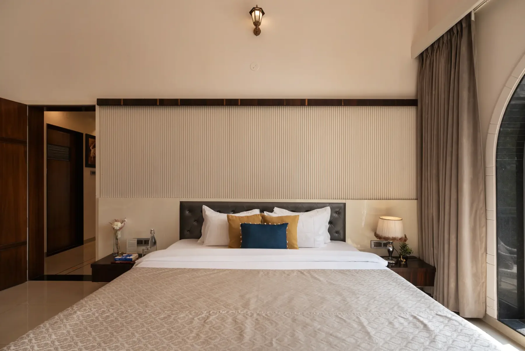 A bedroom with a neatly made bed and bedside tables.