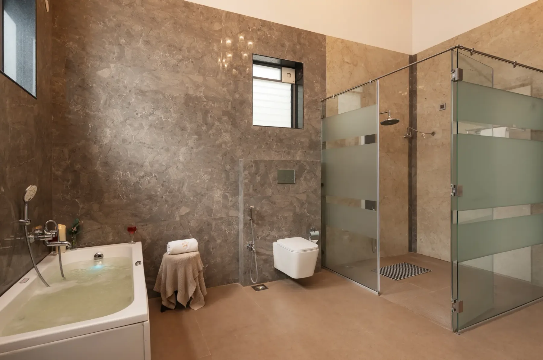 A spacious bathroom with a bathtub and glass shower enclosure.