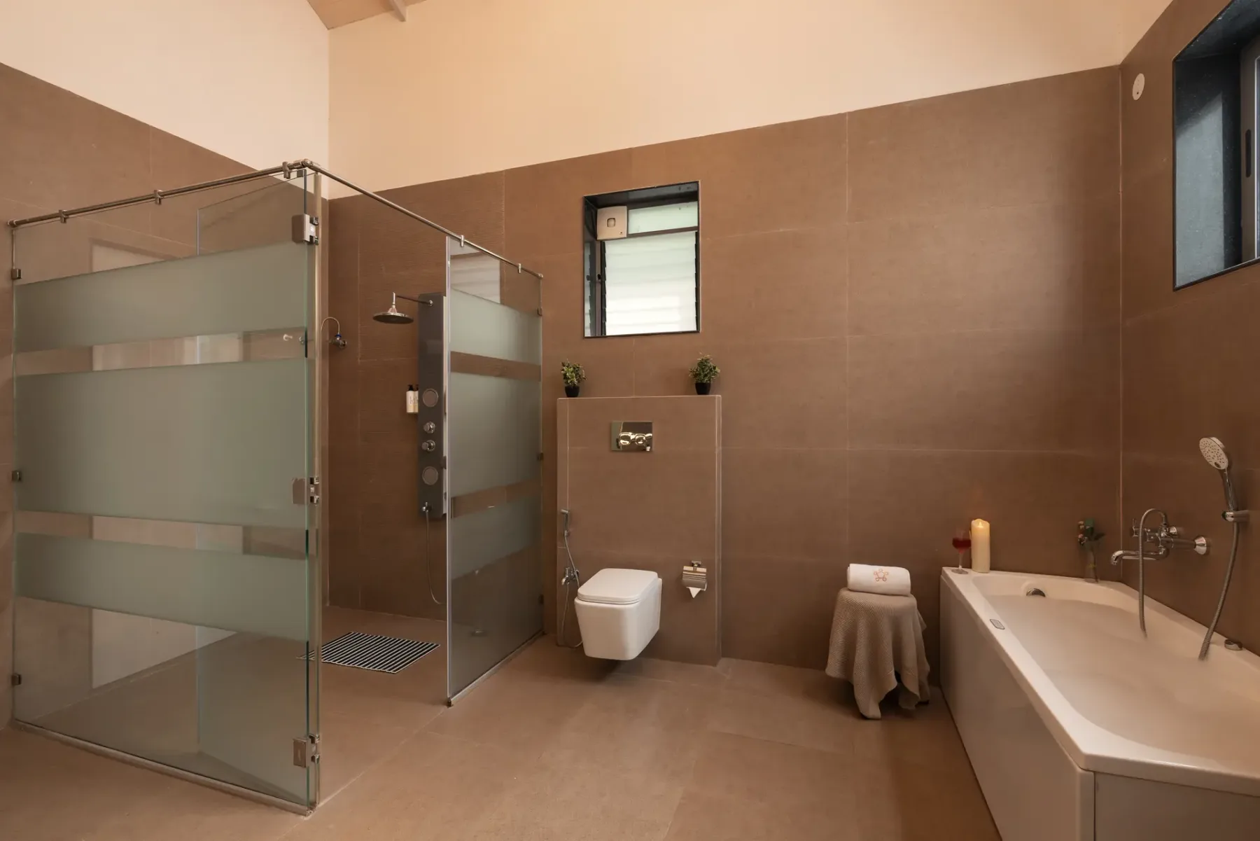A spacious bathroom with a glass shower enclosure and a bathtub.
