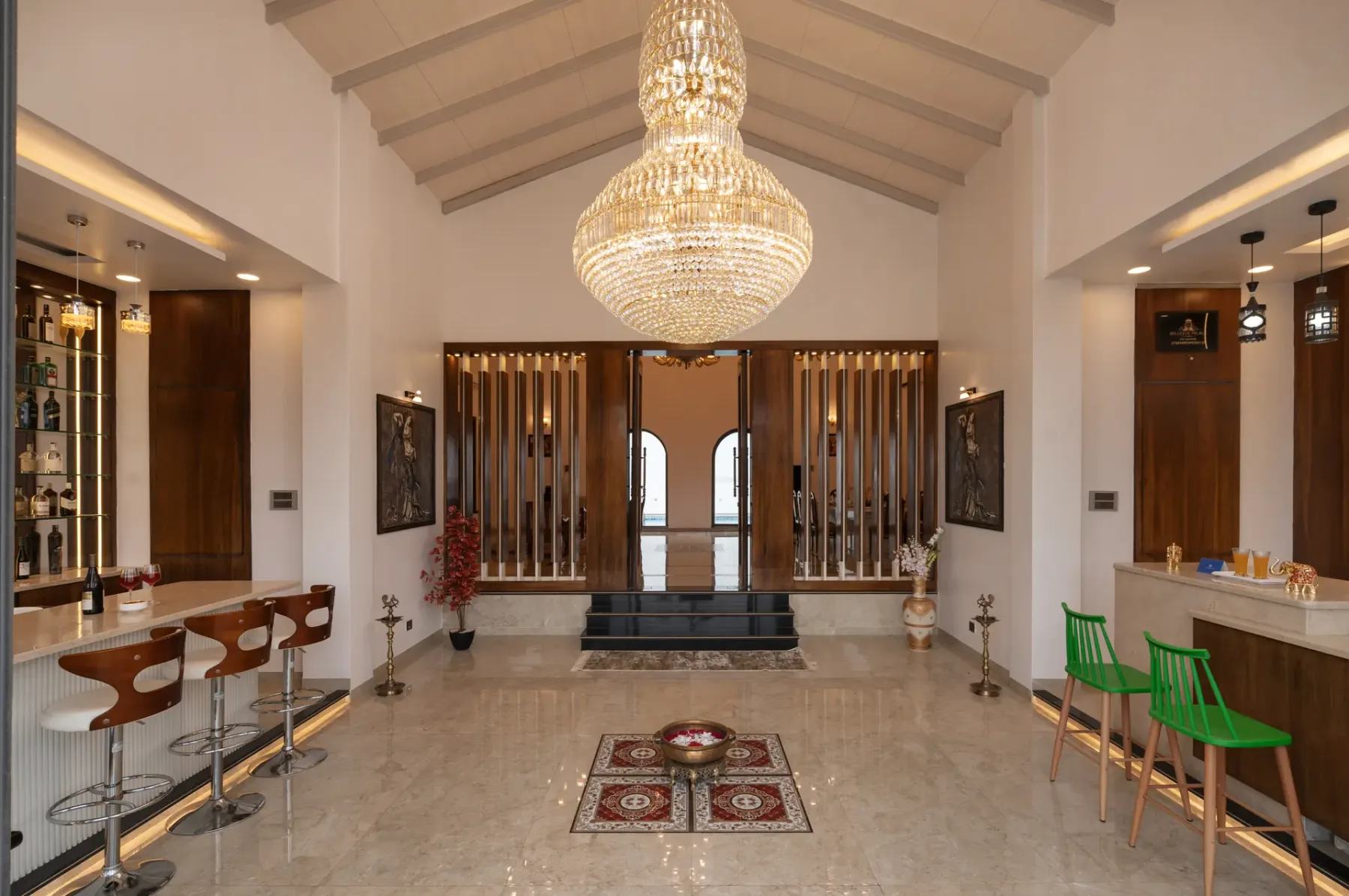 A spacious interior with a large chandelier, a bar, and seating along the sides.