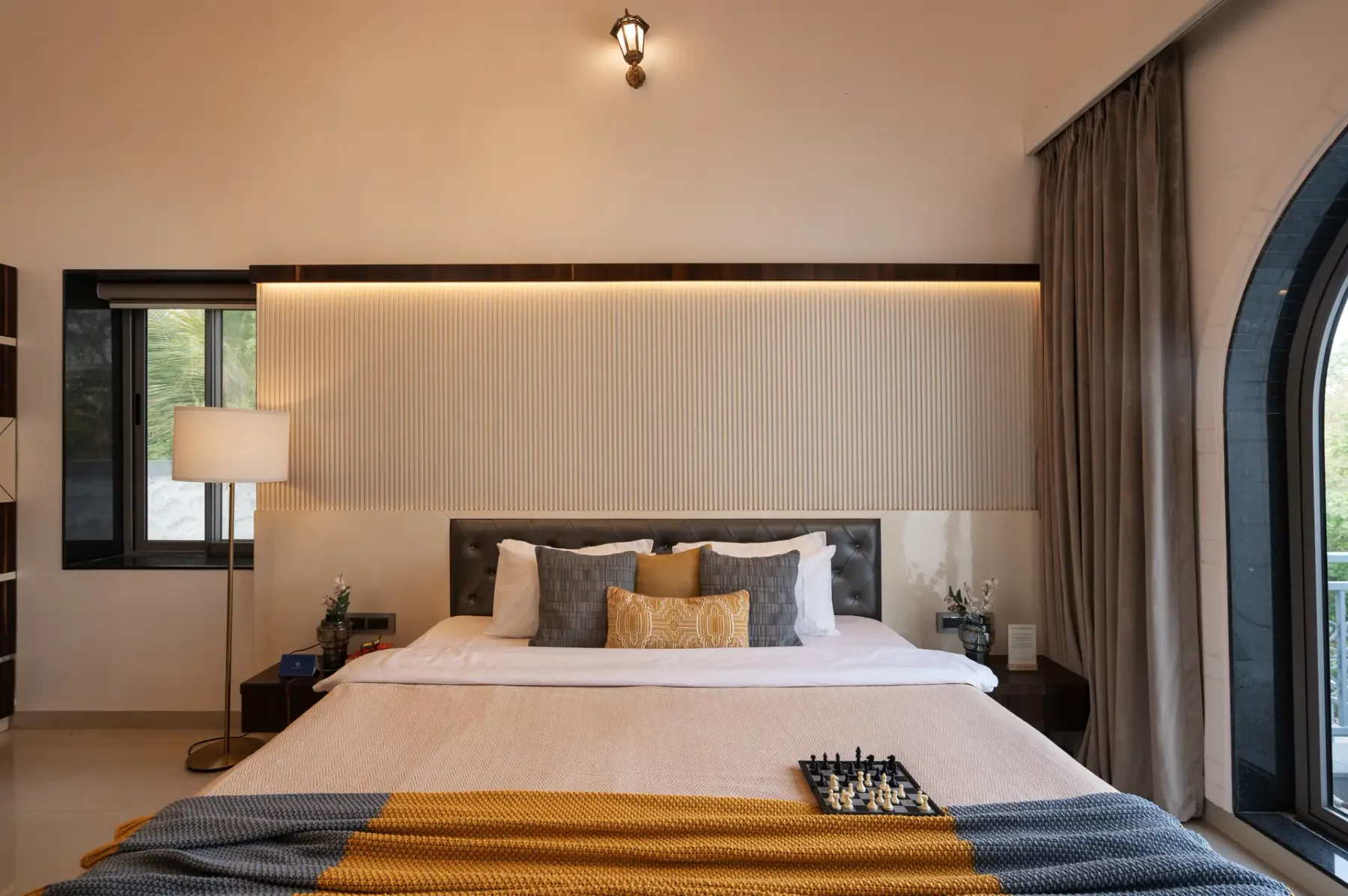 A bedroom with a neatly made bed and bedside tables.