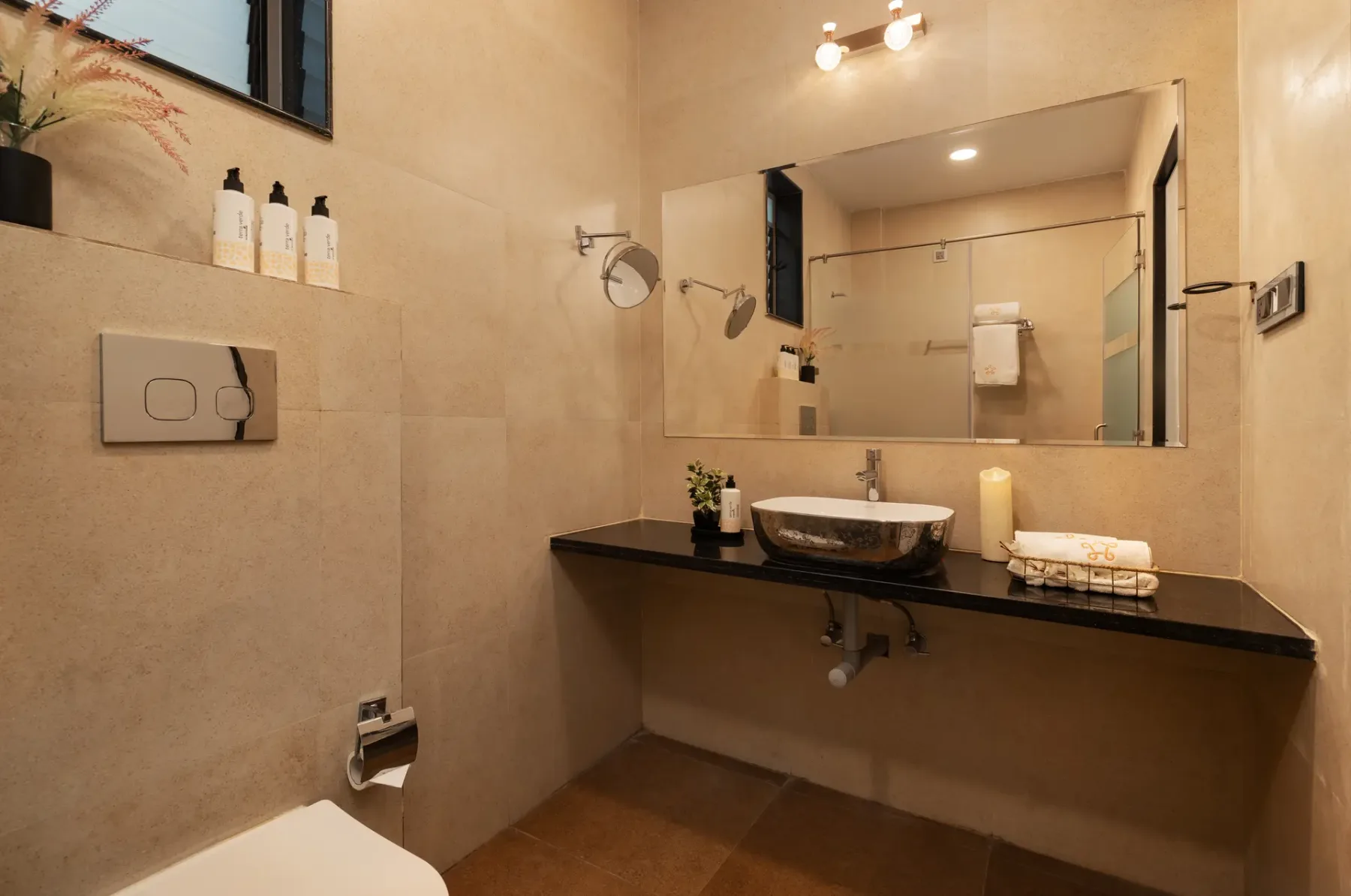 A bathroom with a vessel sink beneath a large wall mirror.