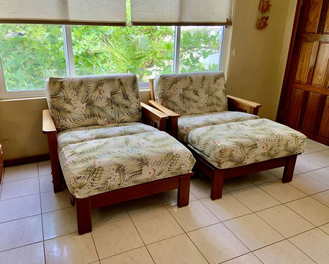 Una zona de estar con dos asientos acolchados de madera junto a una ventana.