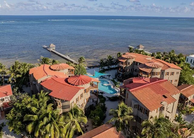 Zona común: Edificios costeros rodean una piscina junto al mar.
