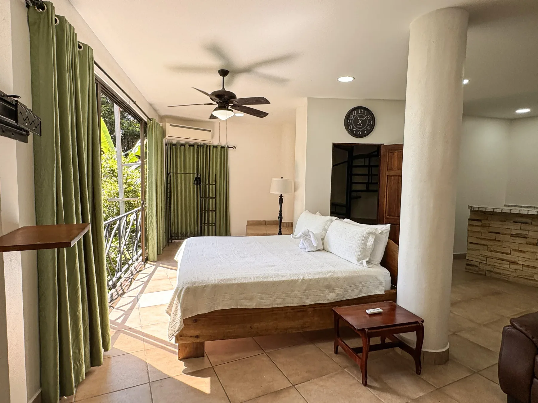 A bedroom with a bed beside glass doors opening onto a balcony.