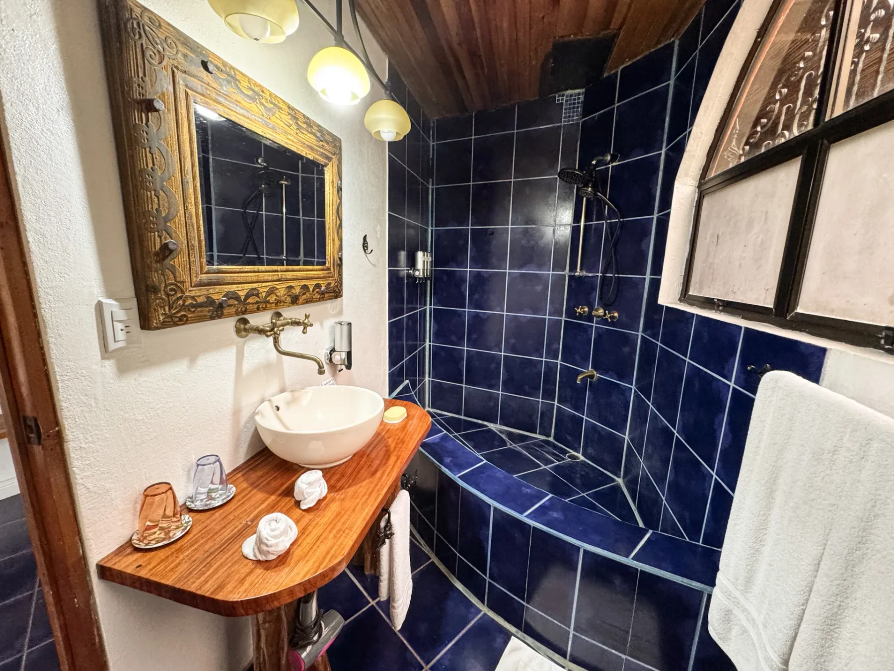 A tiled bathroom with a sink and a built-in shower.