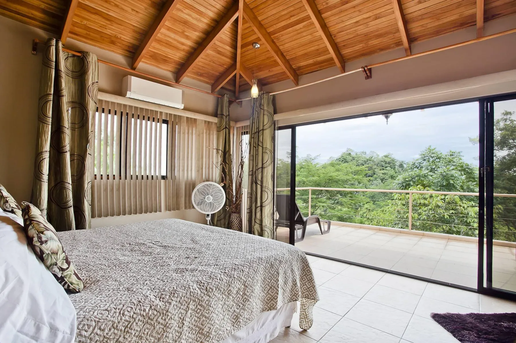 Un dormitorio con una cama junto a puertas corredizas de vidrio que dan a un balcón.
