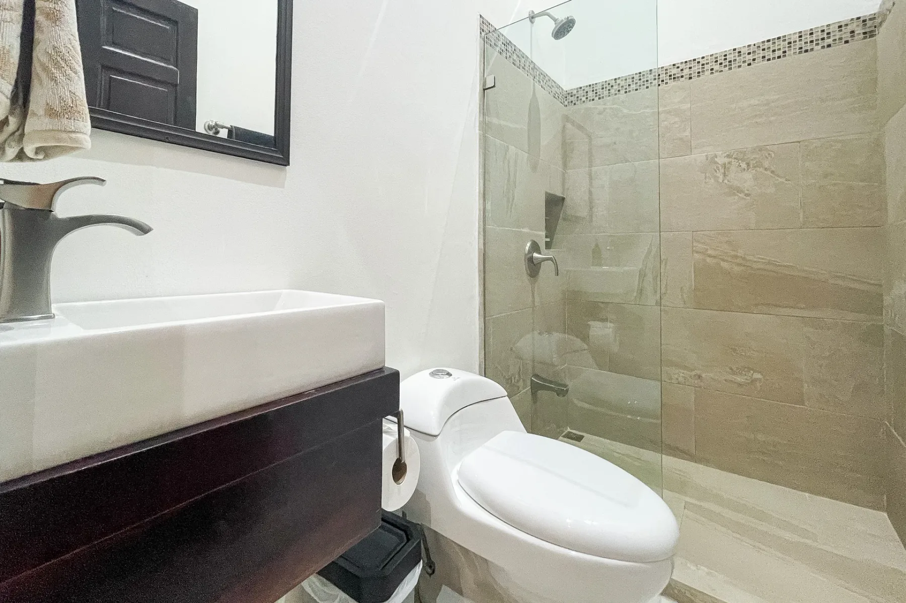 A bathroom with a sink, toilet, and tiled shower.