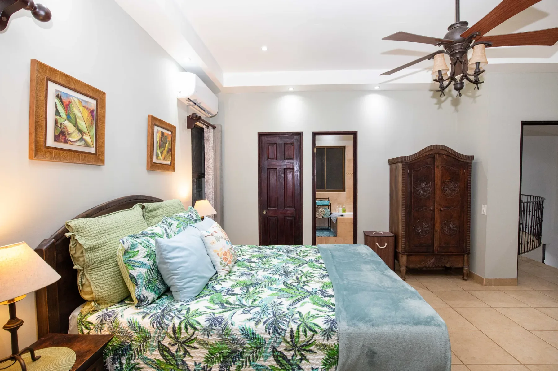 A bedroom with a large bed, patterned bedding, and wooden furnishings.