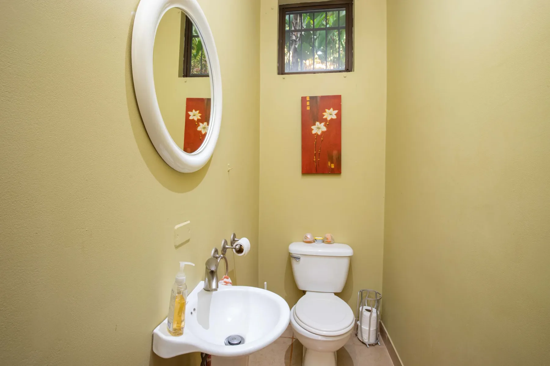 A small bathroom with a wall-mounted sink and toilet.