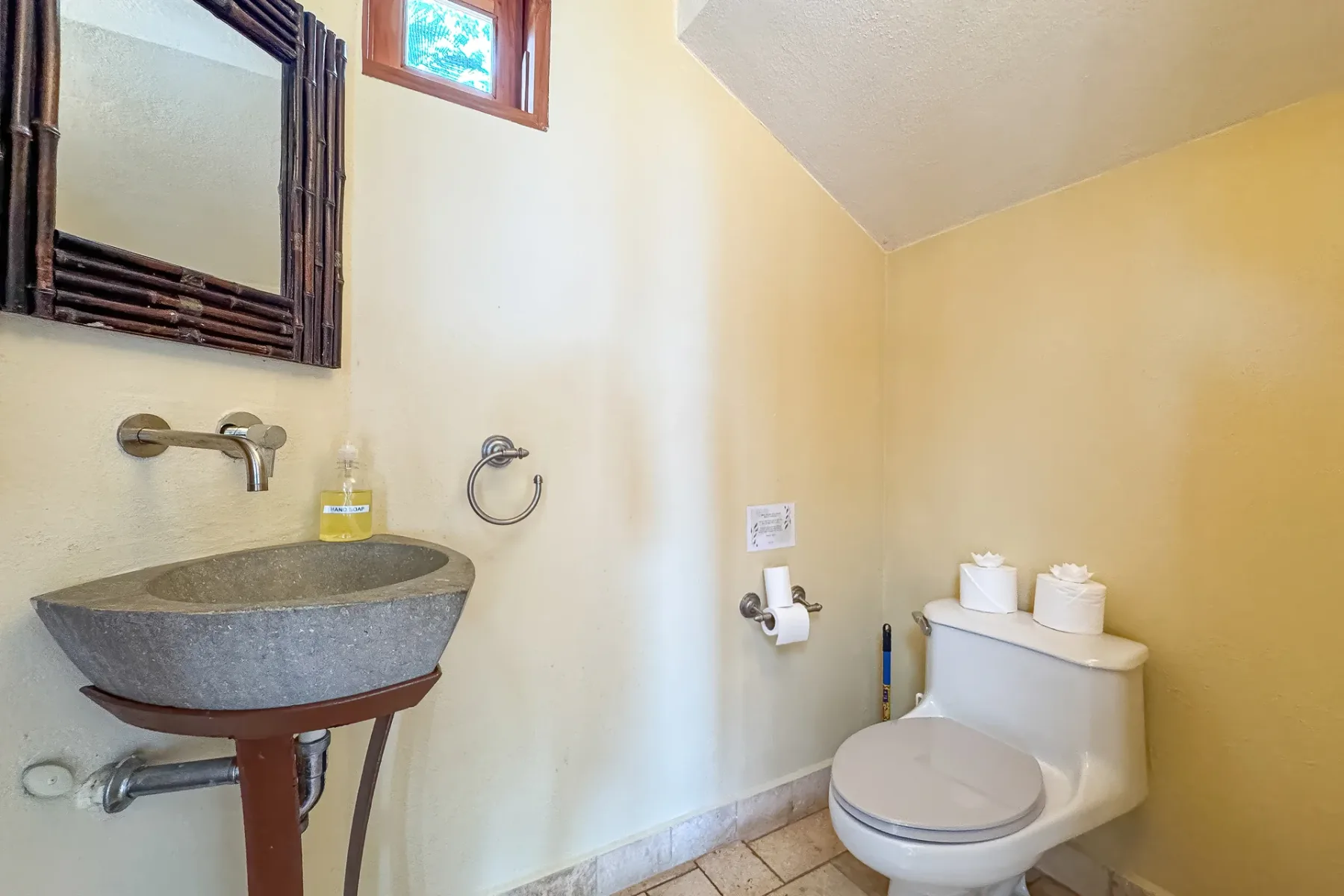 Un baño con un lavabo de pared y un inodoro.