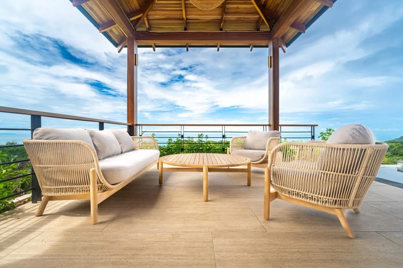 Villa del Cielo · 20. This covered terrace features a natural wood ceiling, comfortable woven seating, and panoramic ocean and jungle views, illuminated by ample natural light.