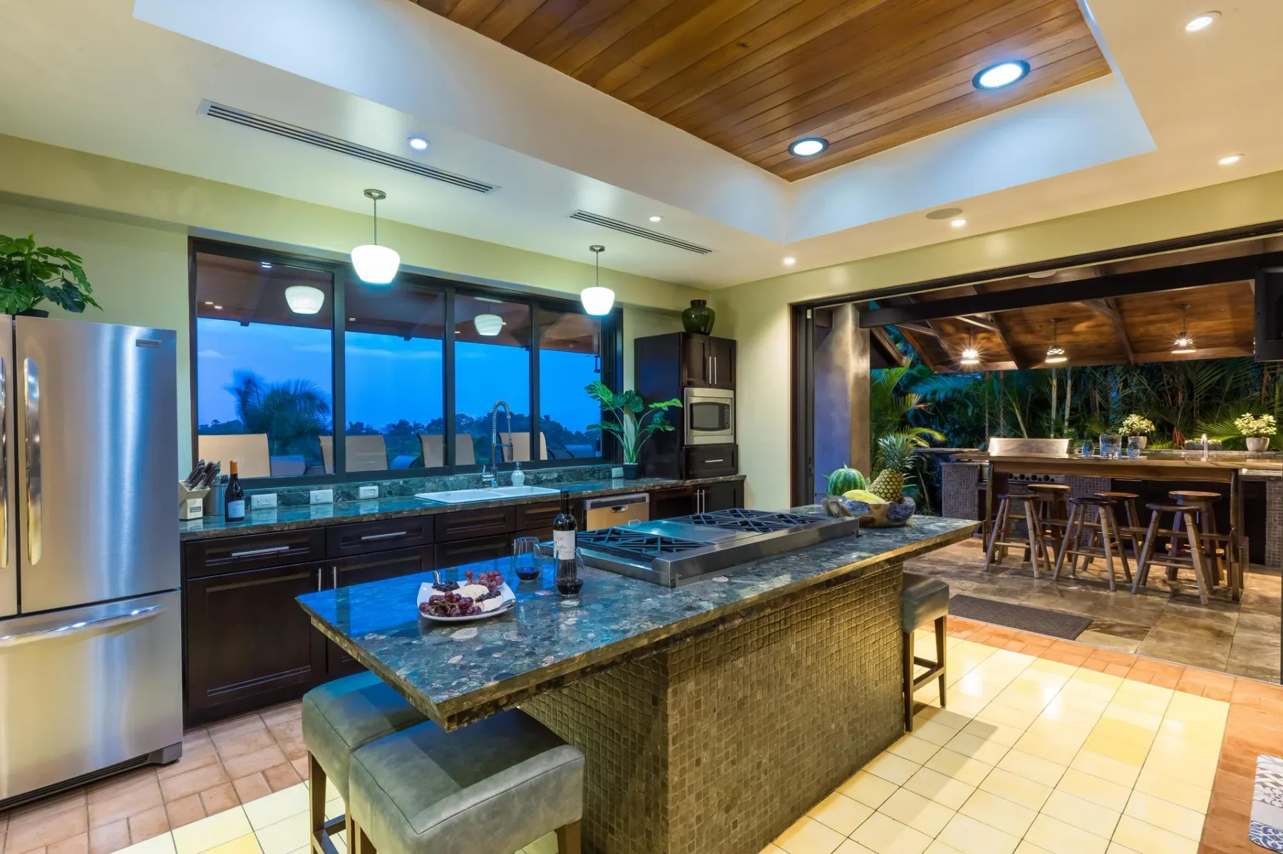A spacious kitchen with a central island and a dining area beyond.