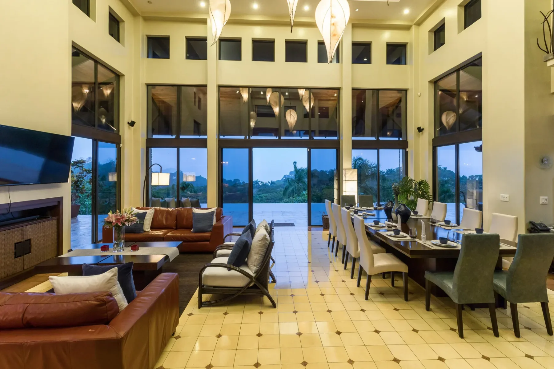 A spacious living and dining area features seating beside tall windows.
