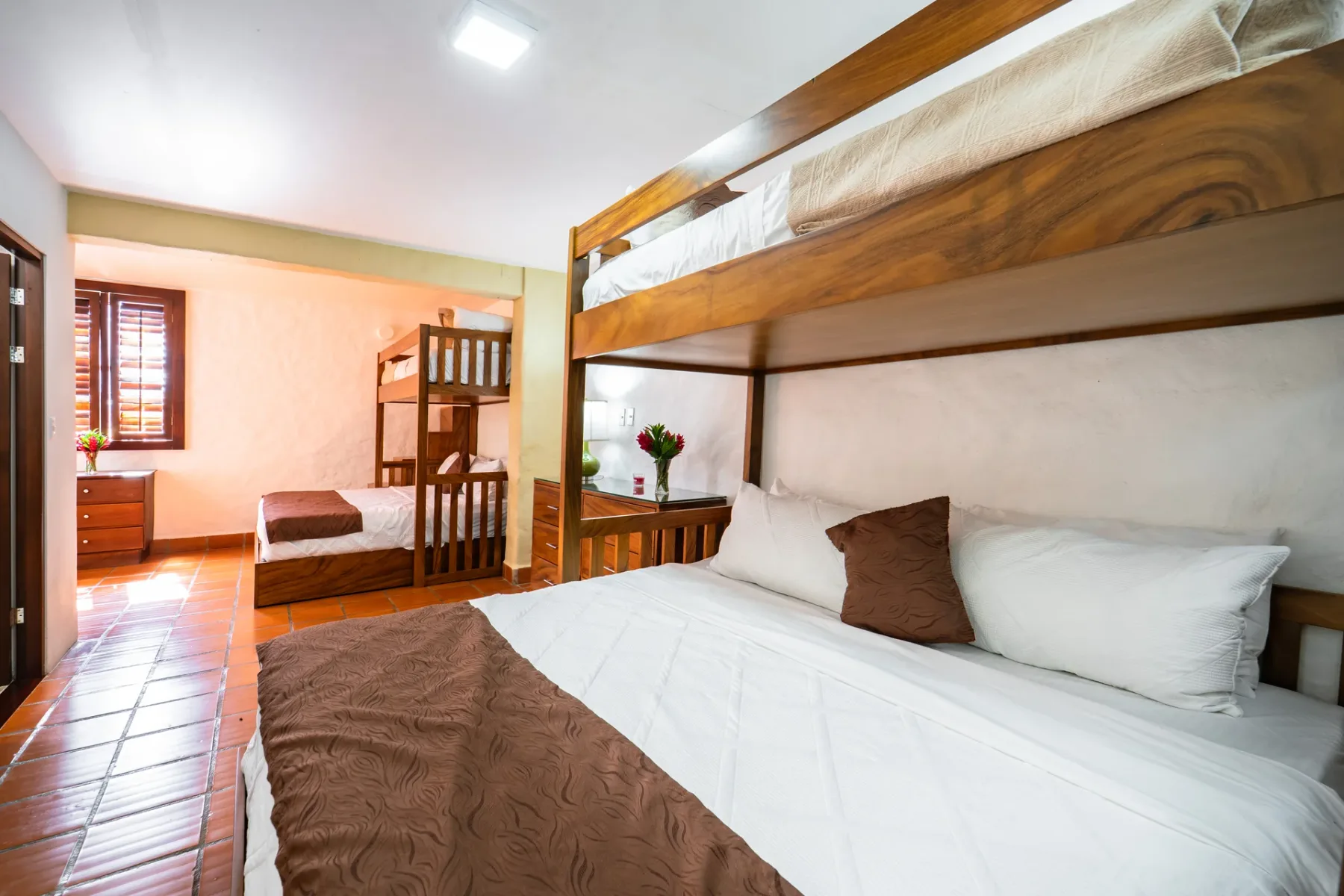 Un dormitorio con literas y ropa de cama blanca.
