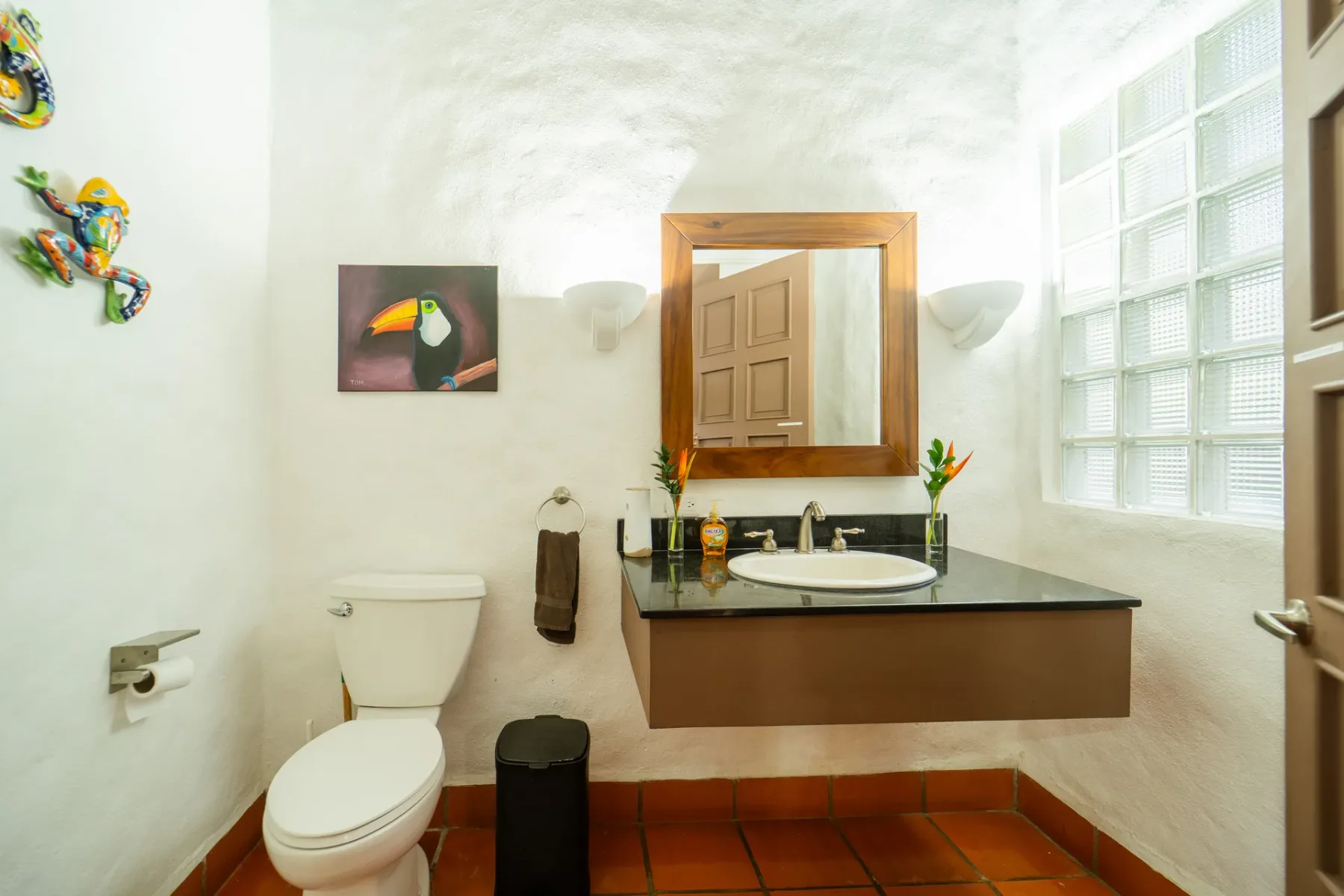Un medio baño con inodoro y lavabo debajo de un espejo.