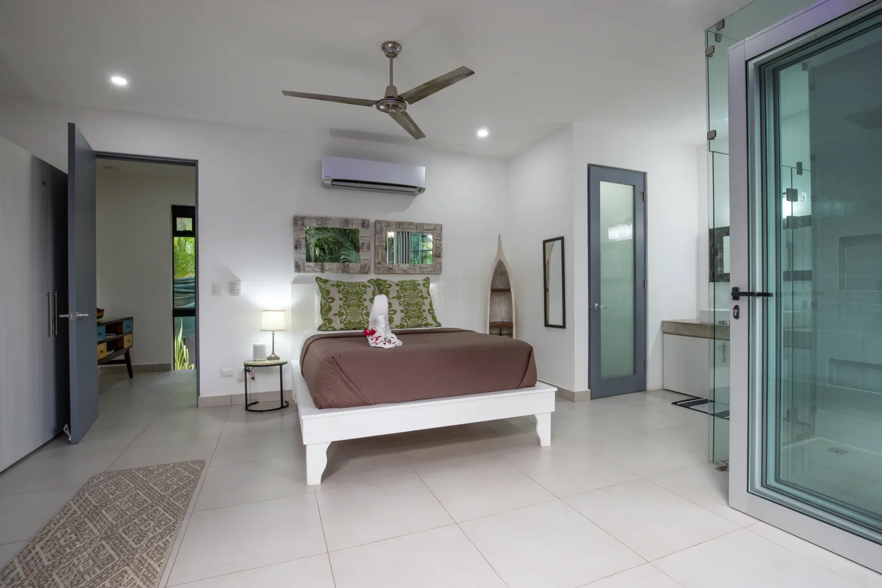 Un dormitorio con una cama, aire acondicionado de pared y puertas de vidrio.