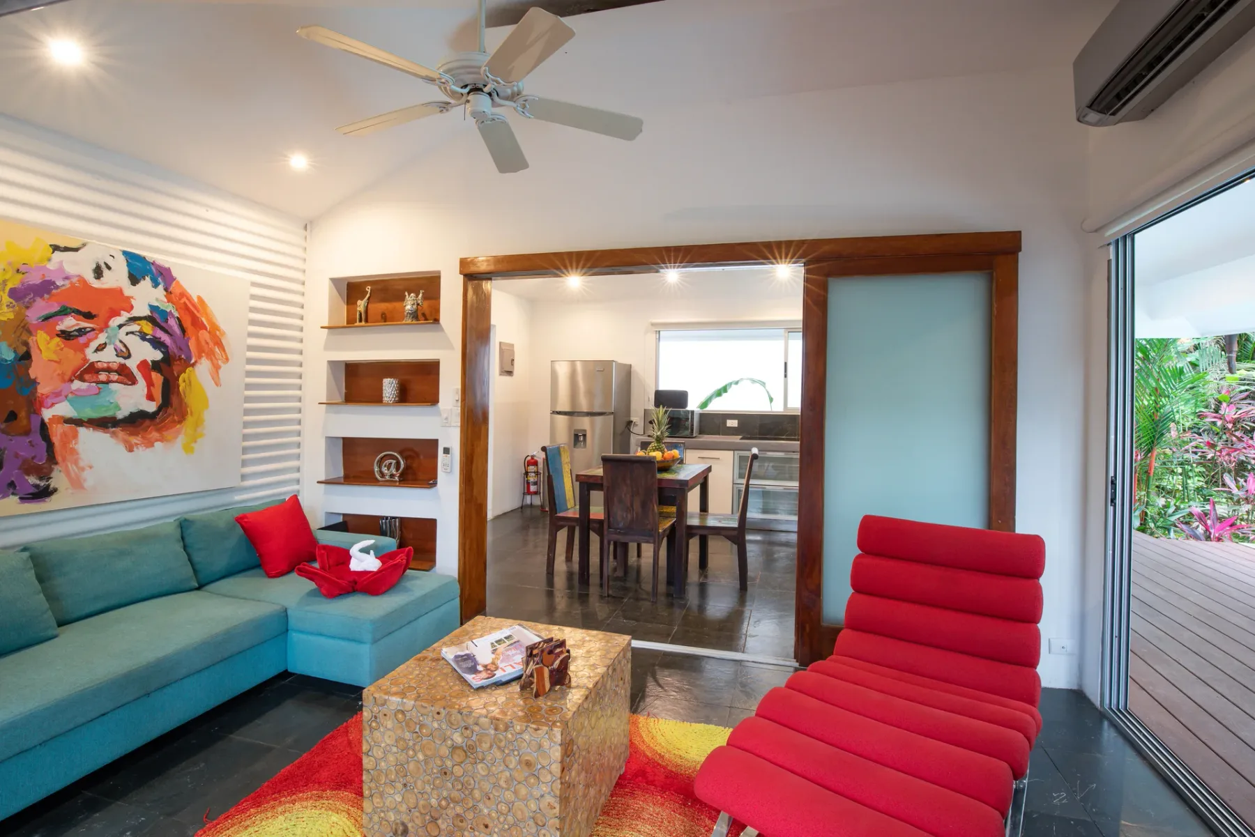 Una sala de estar con arte colorido, asientos y un comedor abierto.