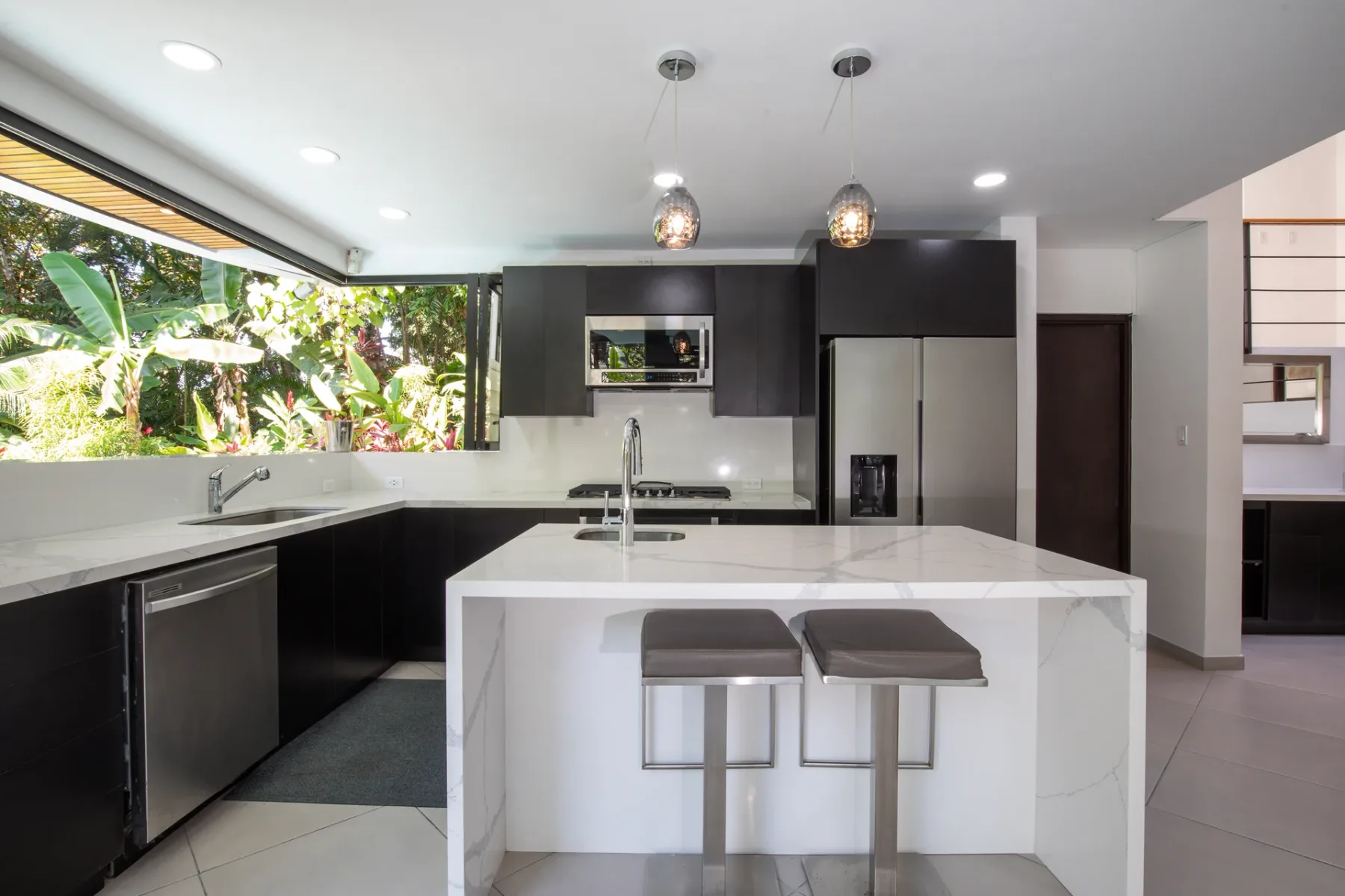 Una cocina moderna con una isla central y dos taburetes.