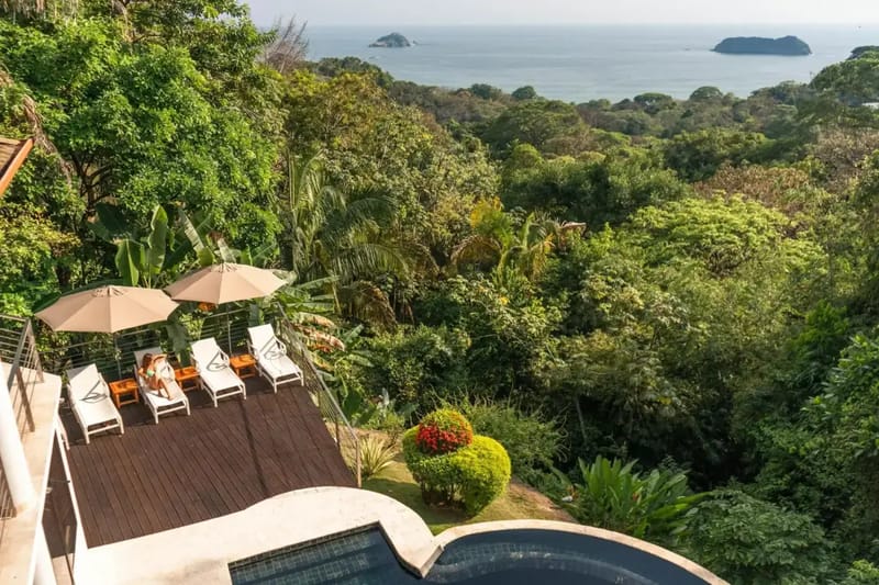 Casa Anjali Luxury Villa · 9. The sun deck and infinity pool are surrounded by tropical rainforest, offering expansive views of the ocean and distant rocky islets.
