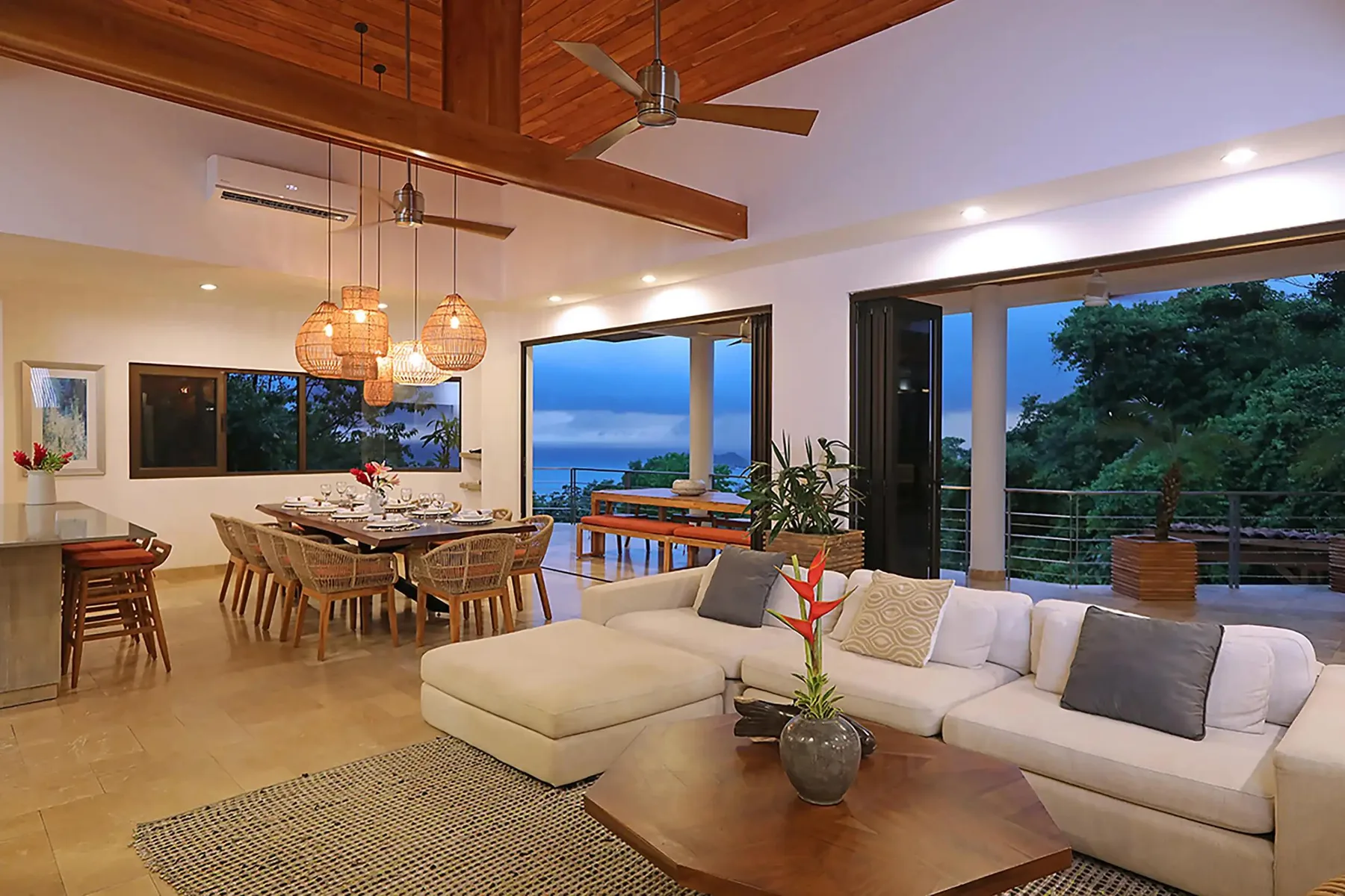 An open-plan living and dining area with seating beside large windows and a balcony.