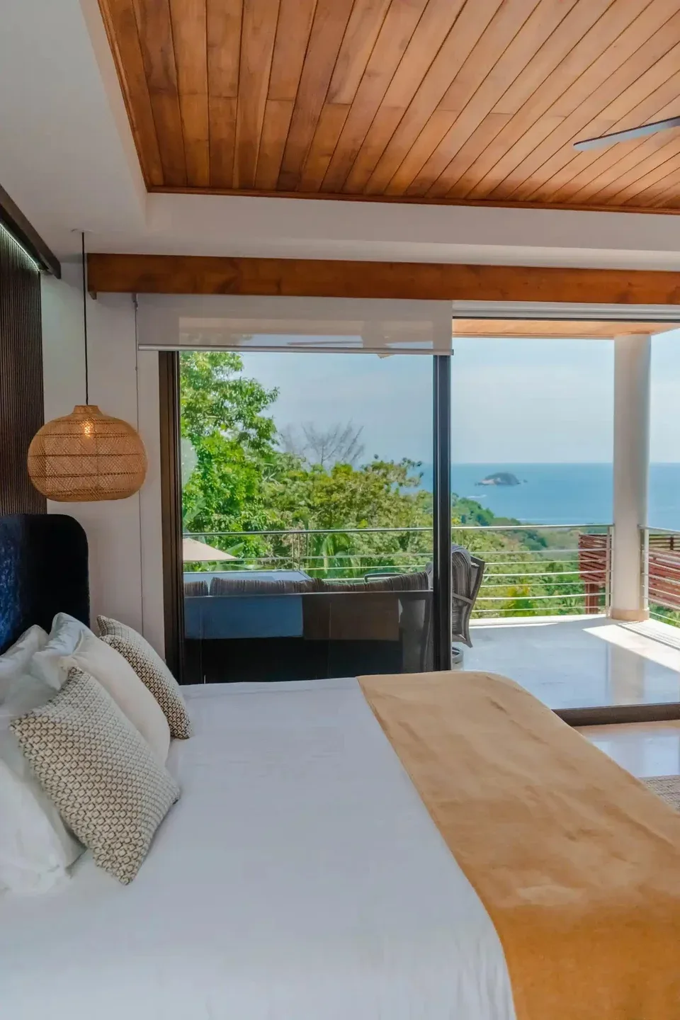 A bedroom opens onto a terrace with a view of the ocean.