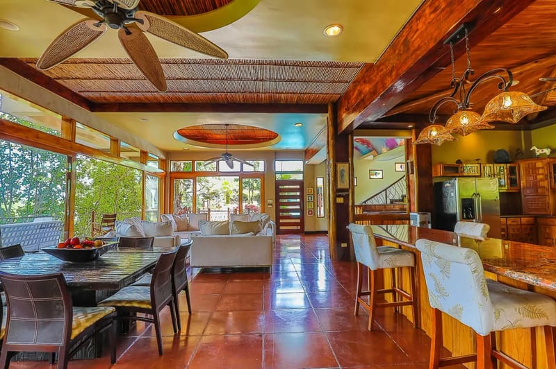 Casa Estrella del Mar · 24. This bright open-plan space, integrating living, dining, and kitchen areas, features natural wood accents and large windows that offer tropical rainforest views and abundant daylight.