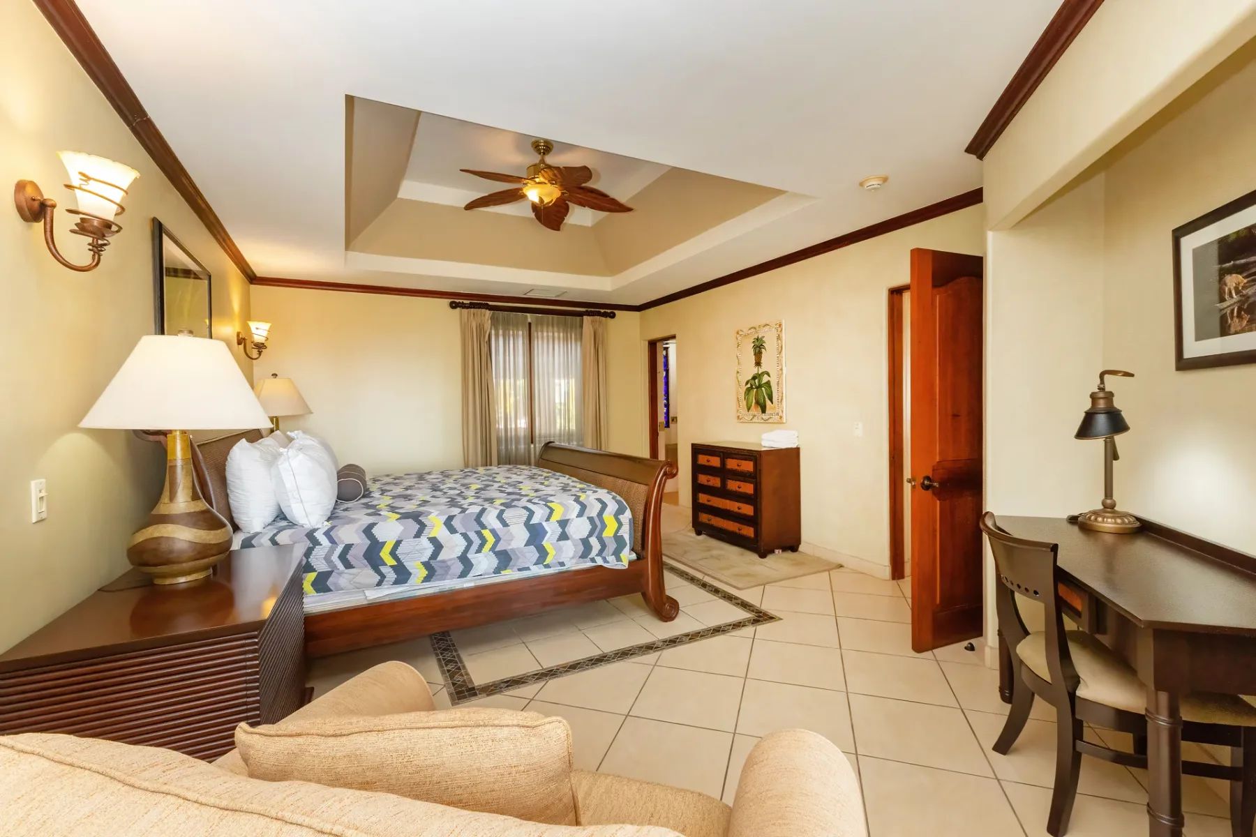 A bedroom with a bed, a dresser, and a small desk.