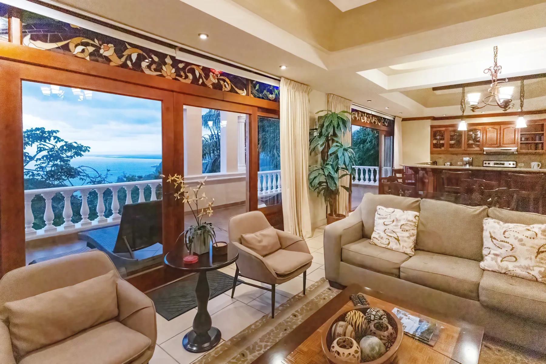 A living room with seating beside large windows overlooking the ocean.