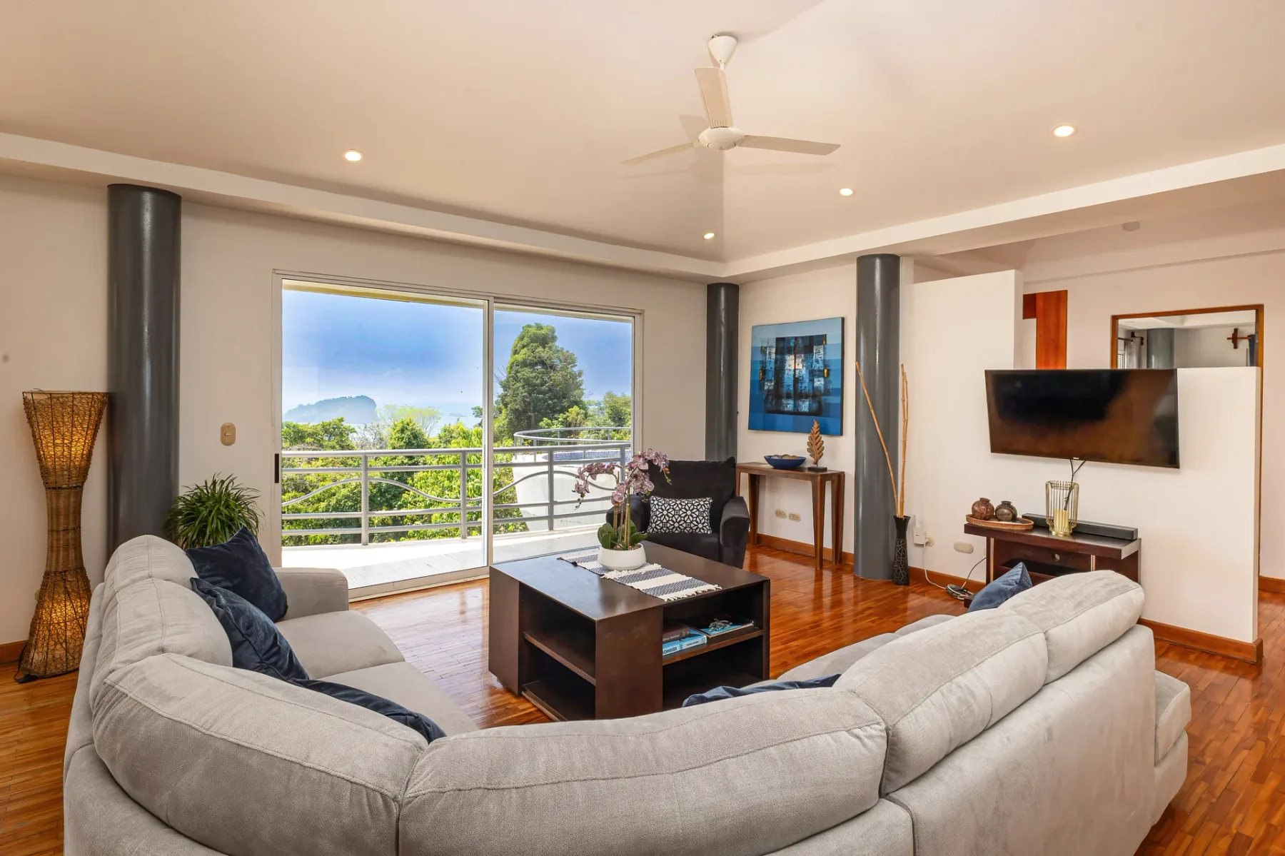 A living room with seating around a coffee table and a television on the wall.