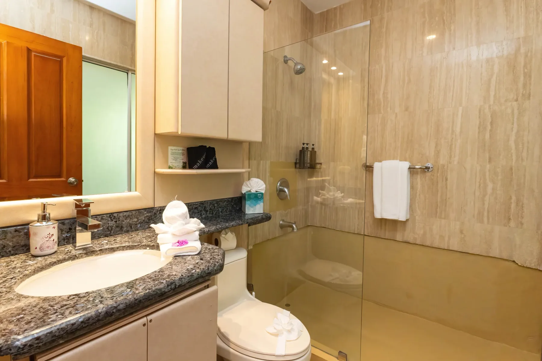 A bathroom with a sink, toilet, and glass shower.