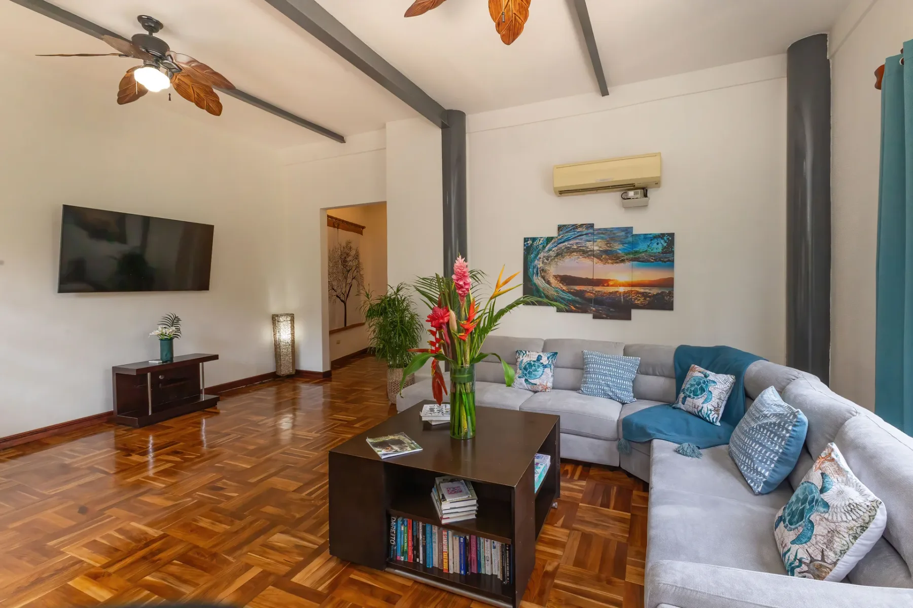 A living room with an L-shaped seating area, coffee table, and wall-mounted television.