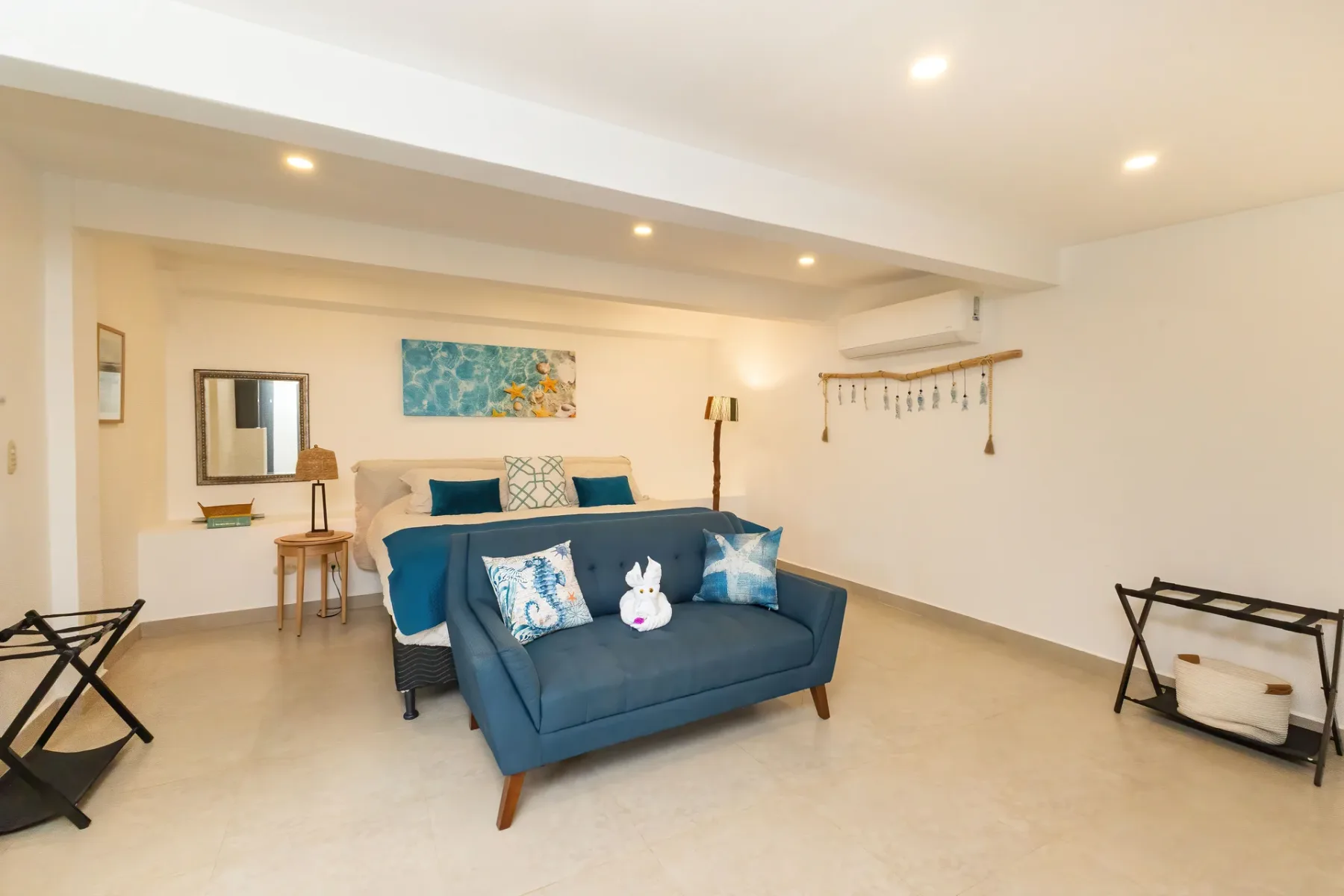 A bright living room with blue seating and wall art.
