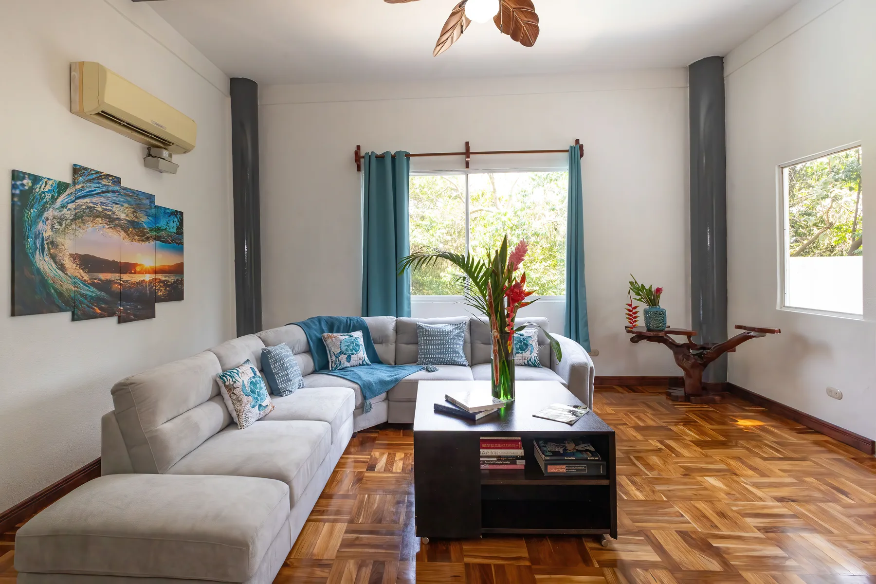 A bright living room with seating around a coffee table and large windows.